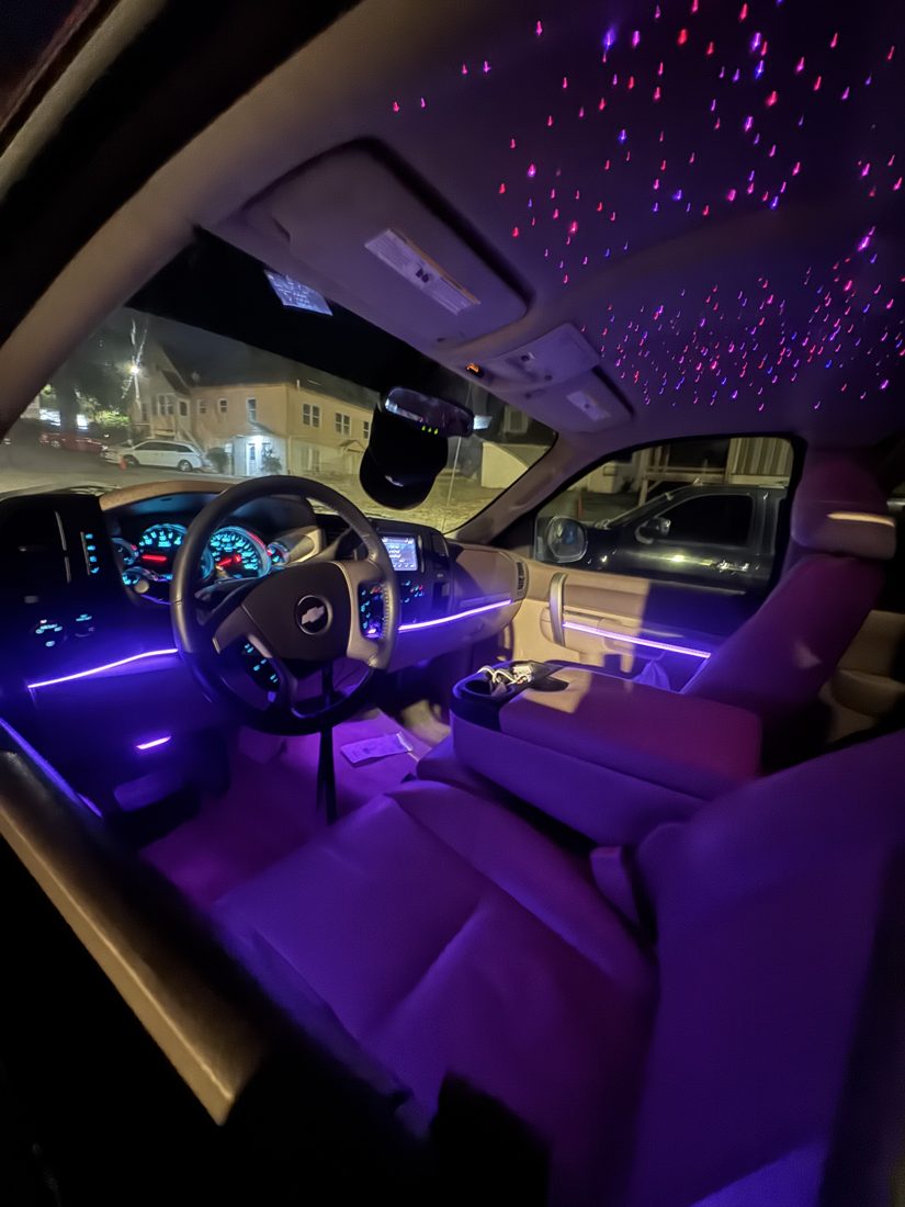 Pink and purple starlight headliner with ambient trim lighting in a truck cab